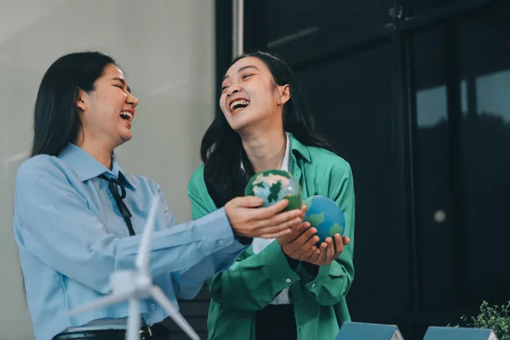 Hands of Asian business professionals analyzing ESG financial data and renewable energy project plans