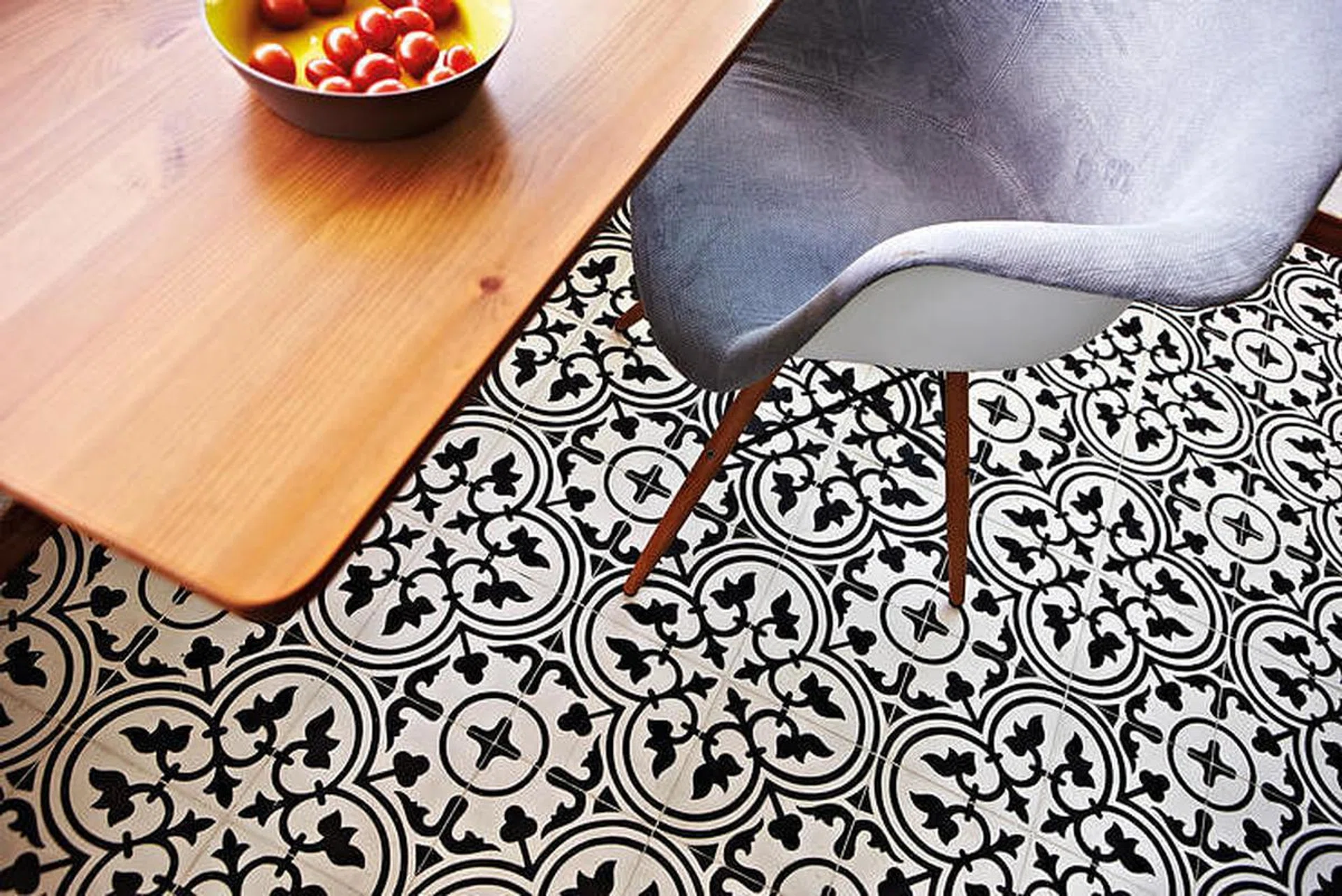 Dining table and chair set on a black and white Peranakan tile flooring. Interior design by Profzile