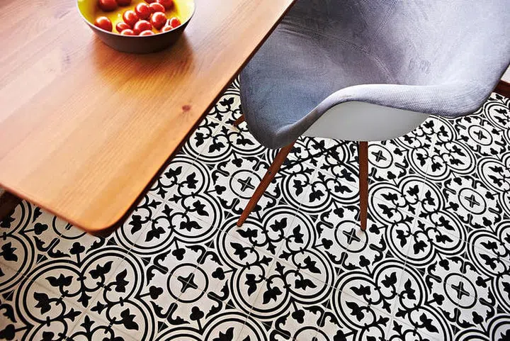 Dining table and chair set on a black and white Peranakan tile flooring. Interior design by Profzile