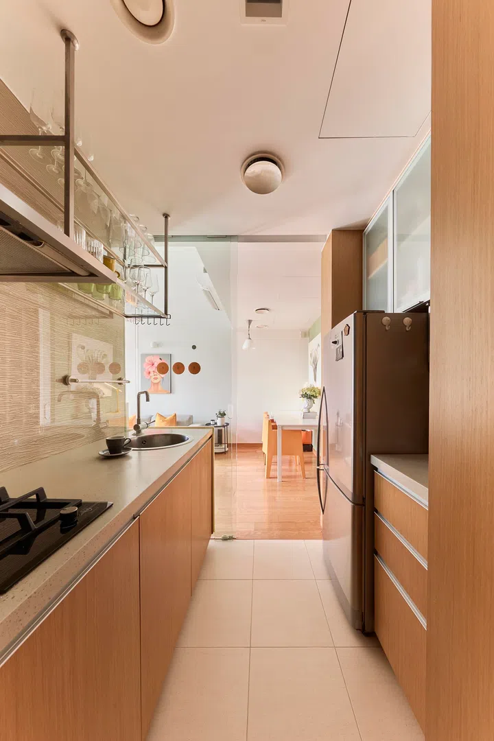 A compact galley kitchen keeps everything within easy reach, with timber cabinetry adding warmth to the functional layout.
