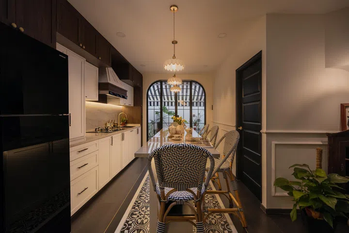 The kitchen’s custom carpentry and colonial touches frame a clear line of sight to the yard.