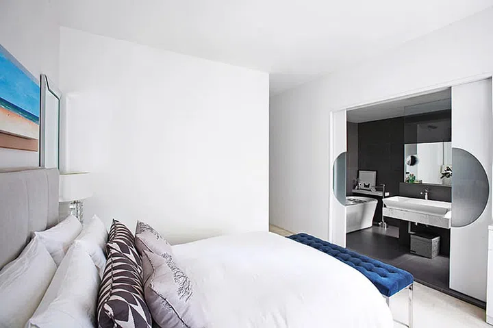 Sliding doors that open flush with the wall give the master bedroom and en-suite bathroom an open-concept feel.