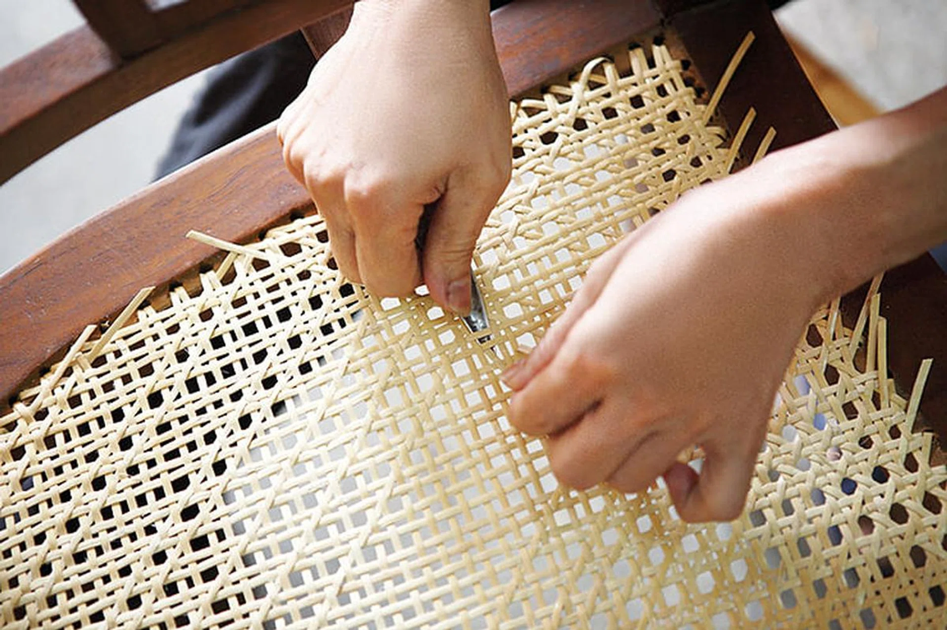 Rattan Furniture Craftsman at work weaving a chair