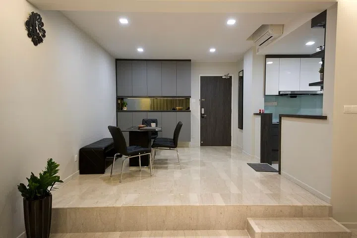 The interior designer hacked away part of the kitchen walls and replacing the original cabinetry with white laminated ones to help the surfaces reflect light better.