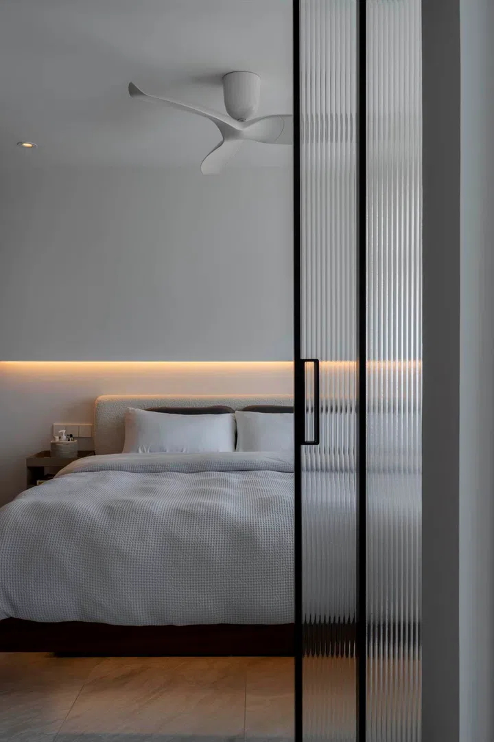 Concealed panels open to reveal the master suite, maintaining the home’s minimalist lines.