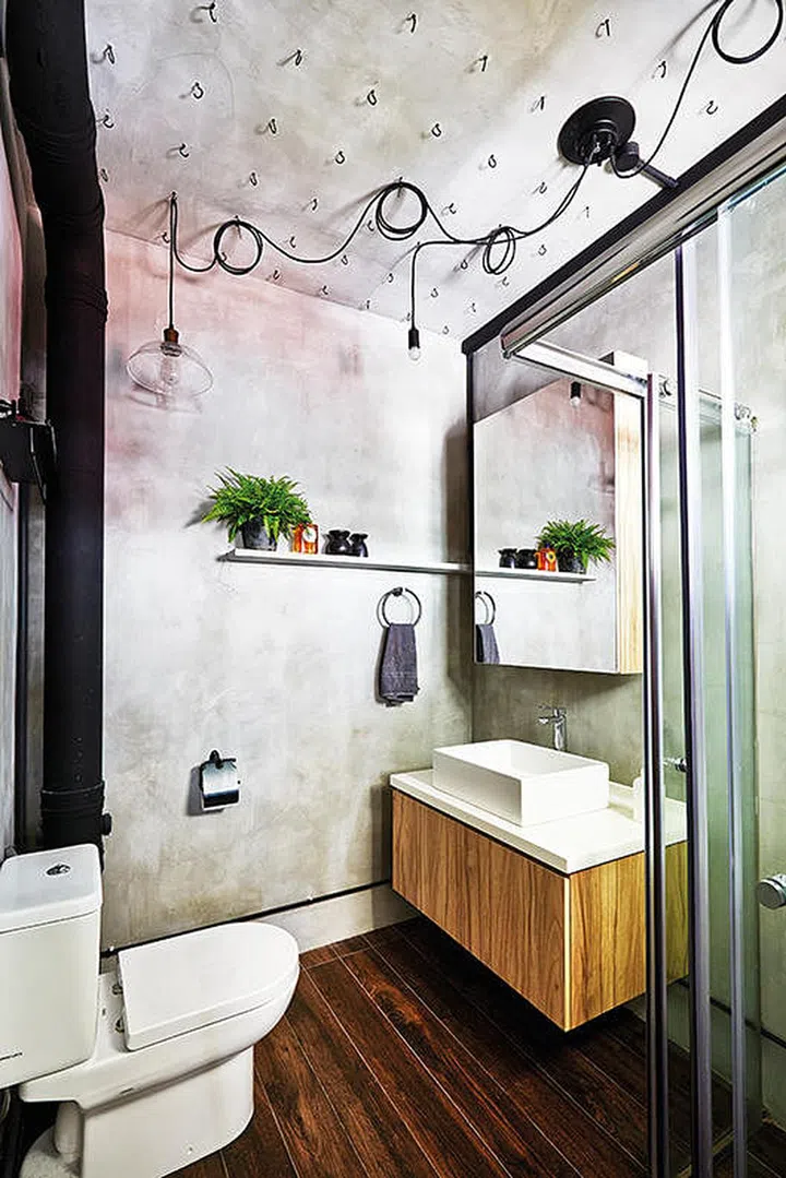 Hooks and snaking light cables on the ceiling continue to make a statement in the master bathroom.