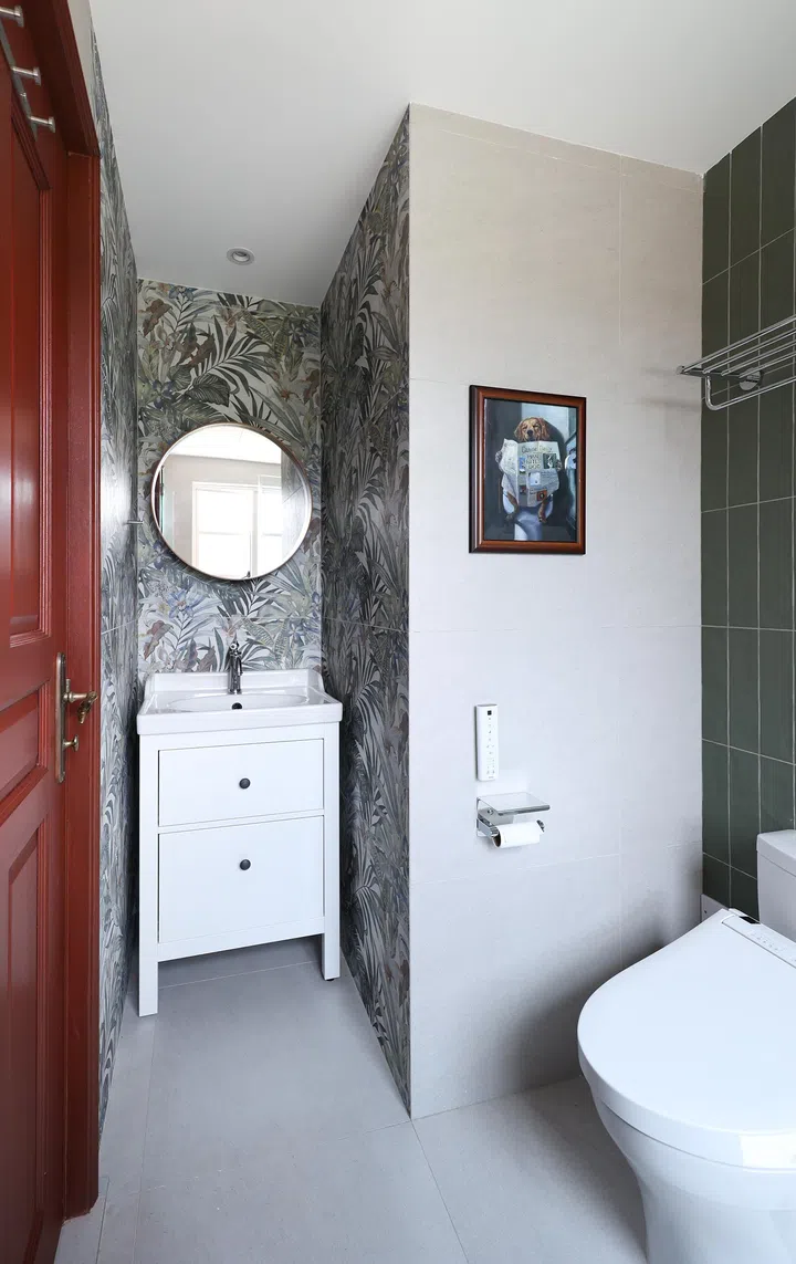 Tropical-print tiles behind the basin energise the space, complemented by calming green subway tiles in the shower.