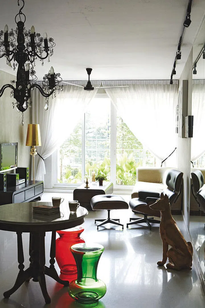 Elements like the touches of gold and fanciful curves tie the different styles in the living room together in interior designer Ong Jia Qi, founder of JQ Ong The Association's 3-bedroom Executive Condominium (EC) in Pasir Ris.