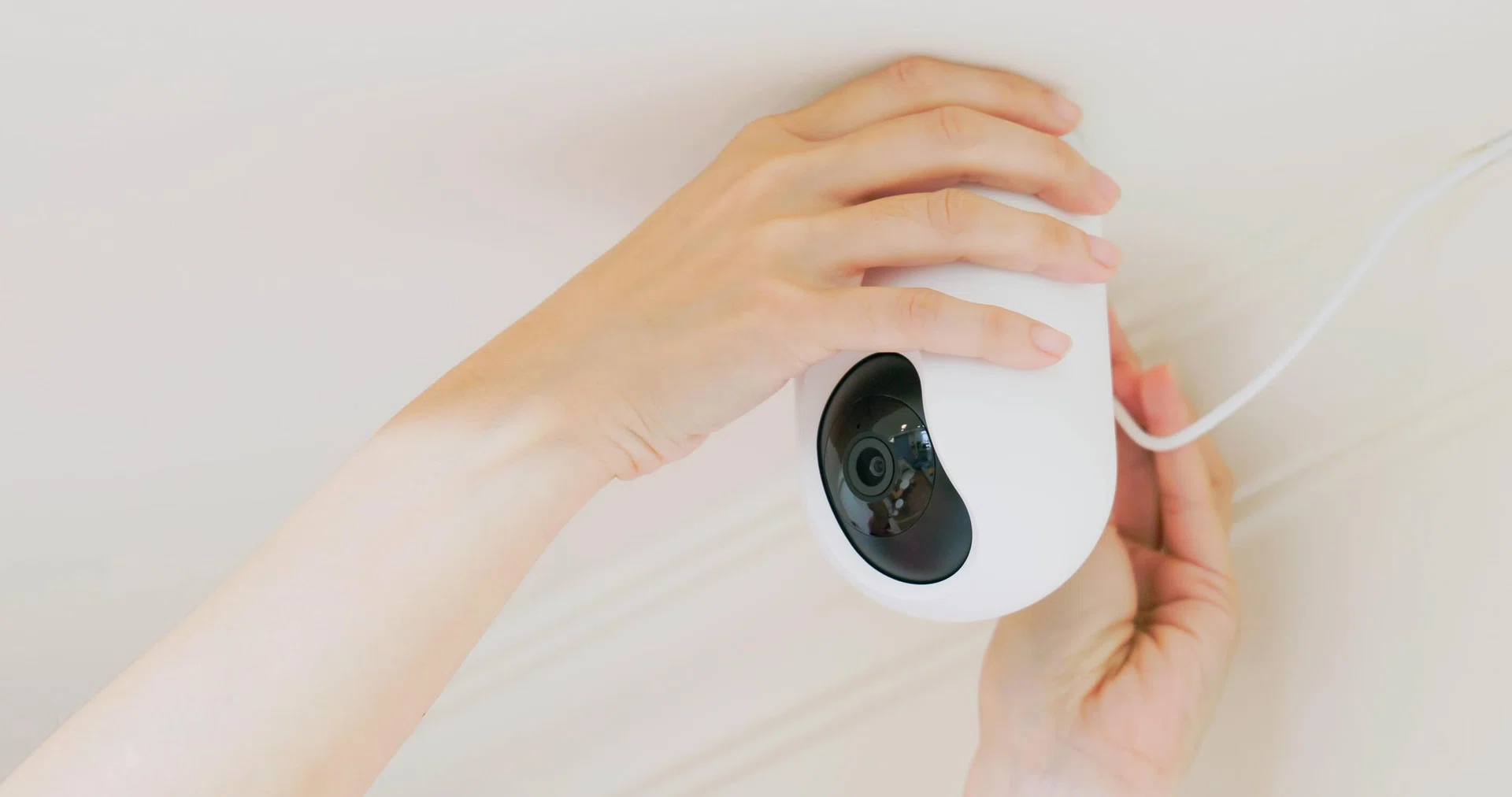 woman is installing surveillance cameras on ceiling at home