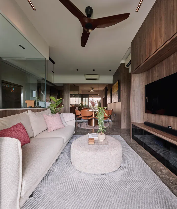 A spacious, tactile living room where warm wood tones, curved forms, and discreet storage create an inviting sense of order and calm.