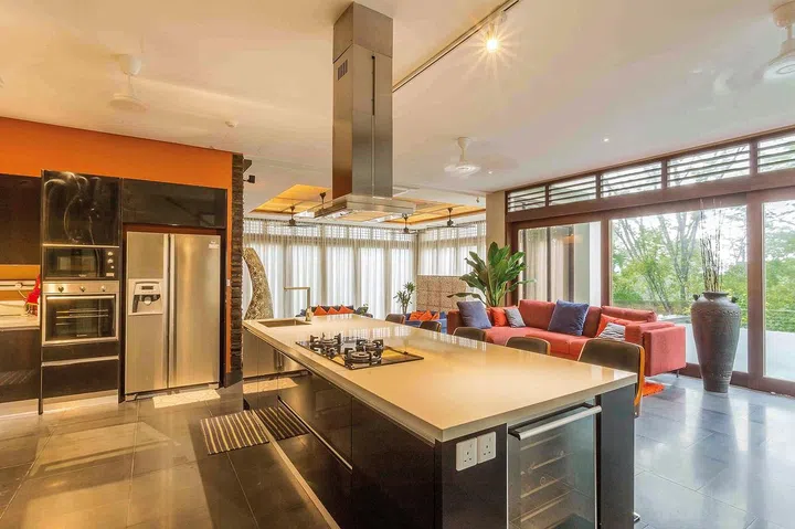 Natural textures blend with solid dashes of blue and red to create a lush and tropical atmosphere.