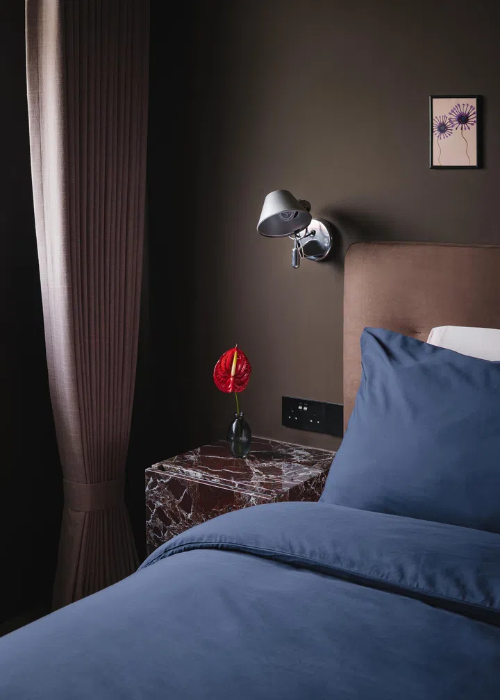 Stone textures were often used to create contrast, including a lot of patterned marble. The homeowners custom-built bedside tables from brown marble. The headboard is from King Living. 