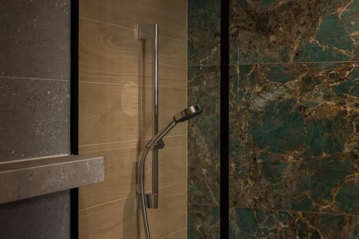 The master bathroom references an onsen bath where granite, wood, and even moss inspired its material choreography.