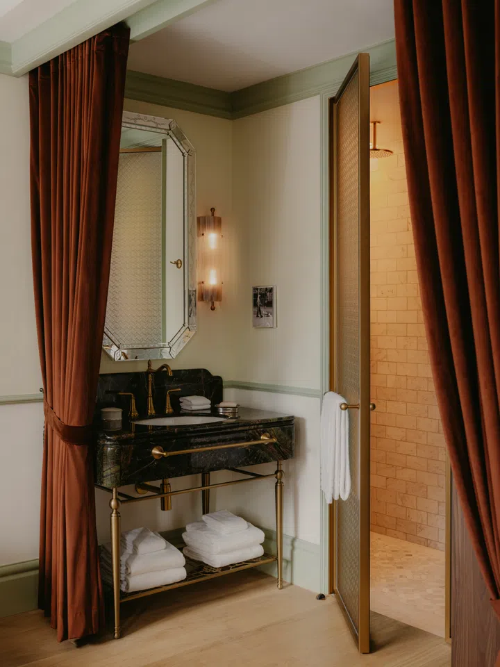 Heavy velvet curtains cloak the vanity sink area.