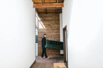 Man moving a sofa out of a door