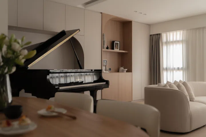 Curved cabinetry, warm wood tones, and a custom piano alcove come together to form a deeply personal corner.