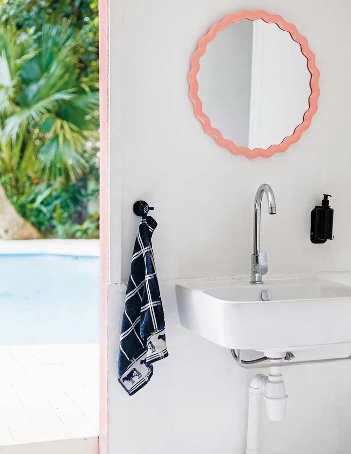 A sink with a pink mirror