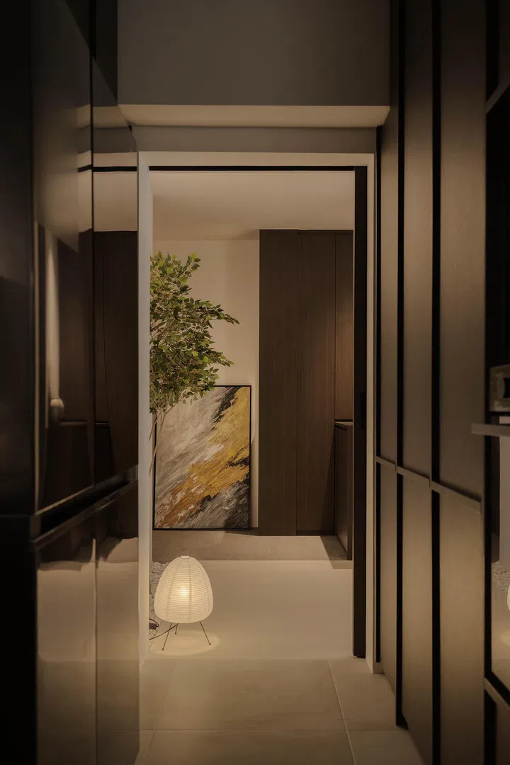  The entryway sets a calm tone with dark wood, warm lighting, and a touch of greenery.
