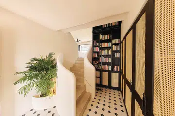 Minimalist stairwell juxtaposed against colonial-style rattan cabinets in a 3-bedroom condo (1,800 sq ft) in Pandan Valley, designed by Insight.Out Studio.