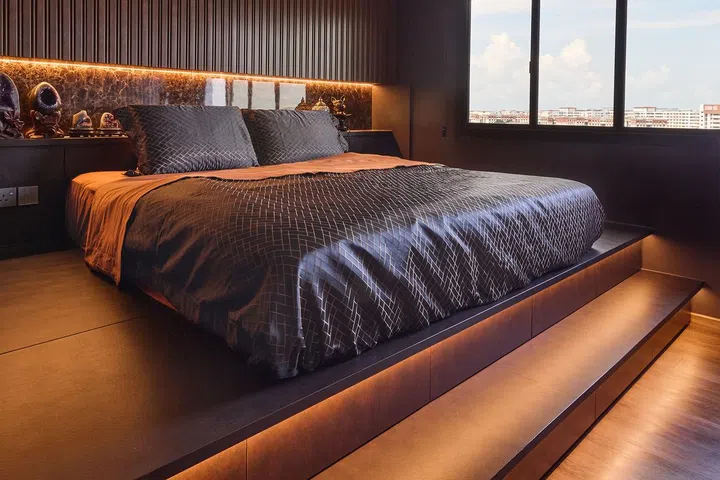 The master bedroom is clad in bronze and gold in a HDB Executive Maisonette in Pasir Ris.