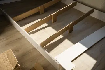 Assembly of a double bed made of wood and lamella.