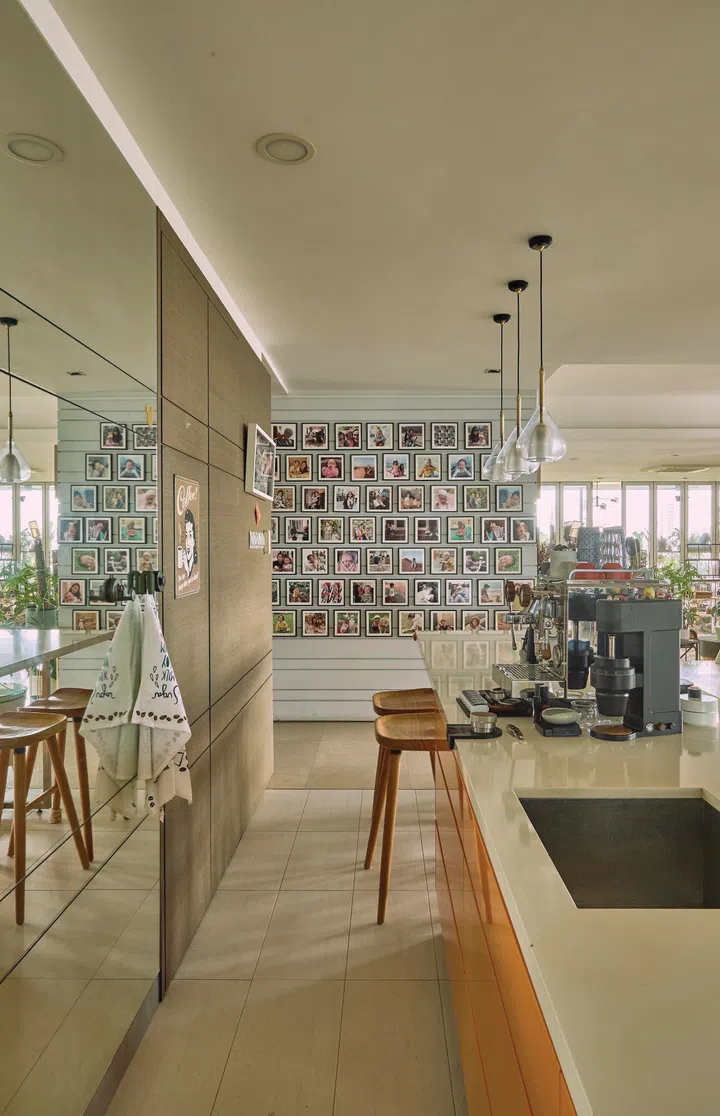 At the far end of the dry kitchen’s island, mixed tiles prints of the daughters’ photos fills the wall.