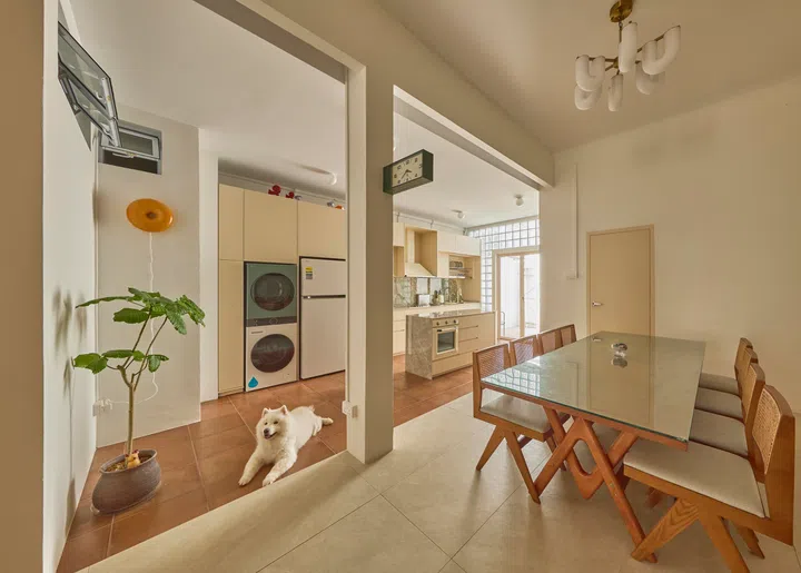The dining area sits between living and kitchen zones, framed by wide openings that preserve clear sightlines across the home.