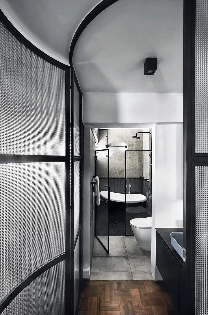 Dramatic curved wall with a curved sliding door to close off the corner of the room where the bathroom is situated