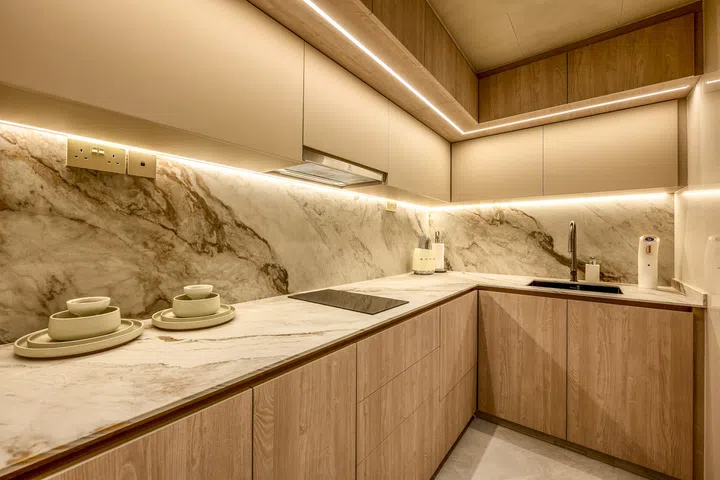 The reconfigured kitchen prioritises everyday functionality while maintaining the home’s warm resort-inspired palette.