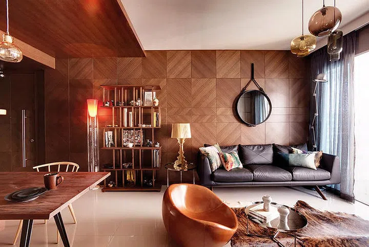 One large wall in the living area is clocked in wood, creating a sense of intimacy in this well-styled space. This space features accessories such as the tinted Niche Modern hand-blown glass pendant lamps, as well as cushions the owner brought back from London.