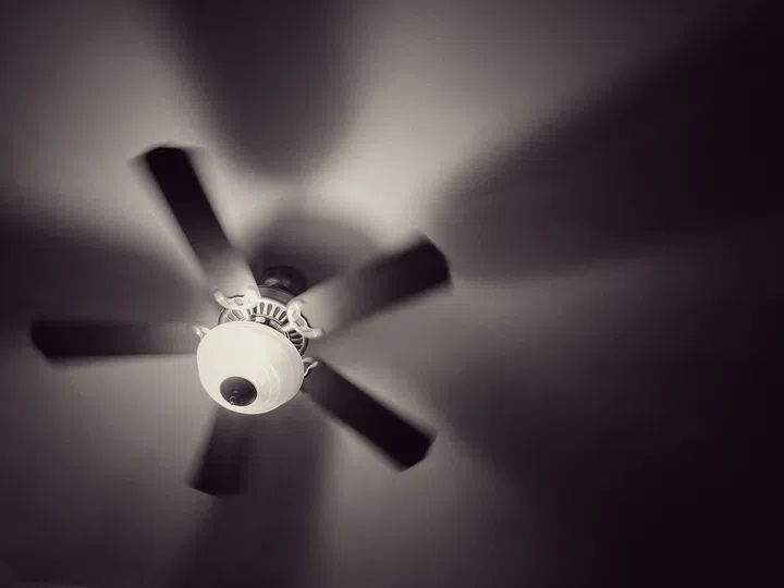 A ceiling fan gently stirs the air, casting soft shadows across the room.