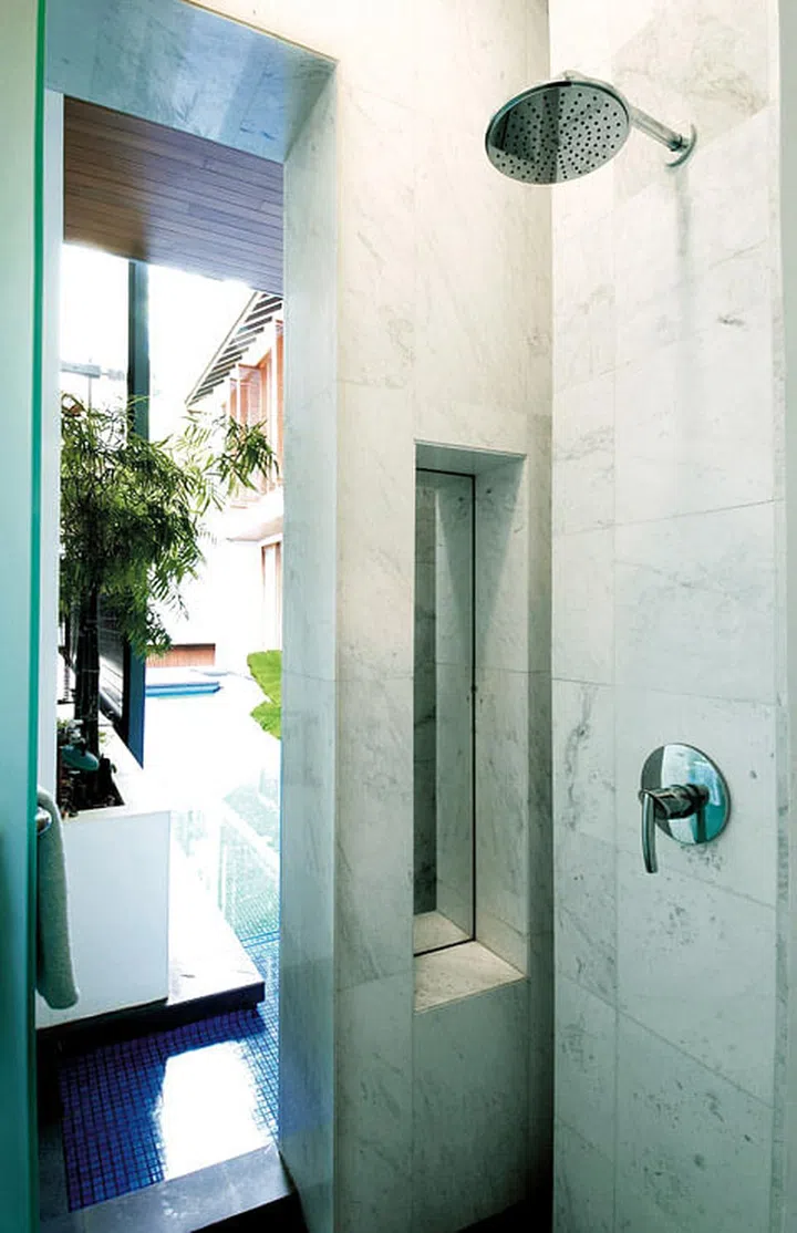 A specially created niche for toiletries also serves as an unobtrusive spot for a useful recessed mirror.