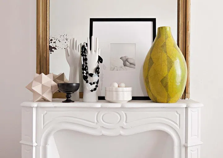 Interesting artworks atop the fireplace in the bedroom.