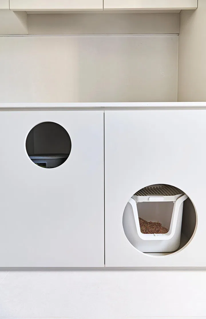 Cute holes in the cabinet provide easy access for her cat to enter and leave.