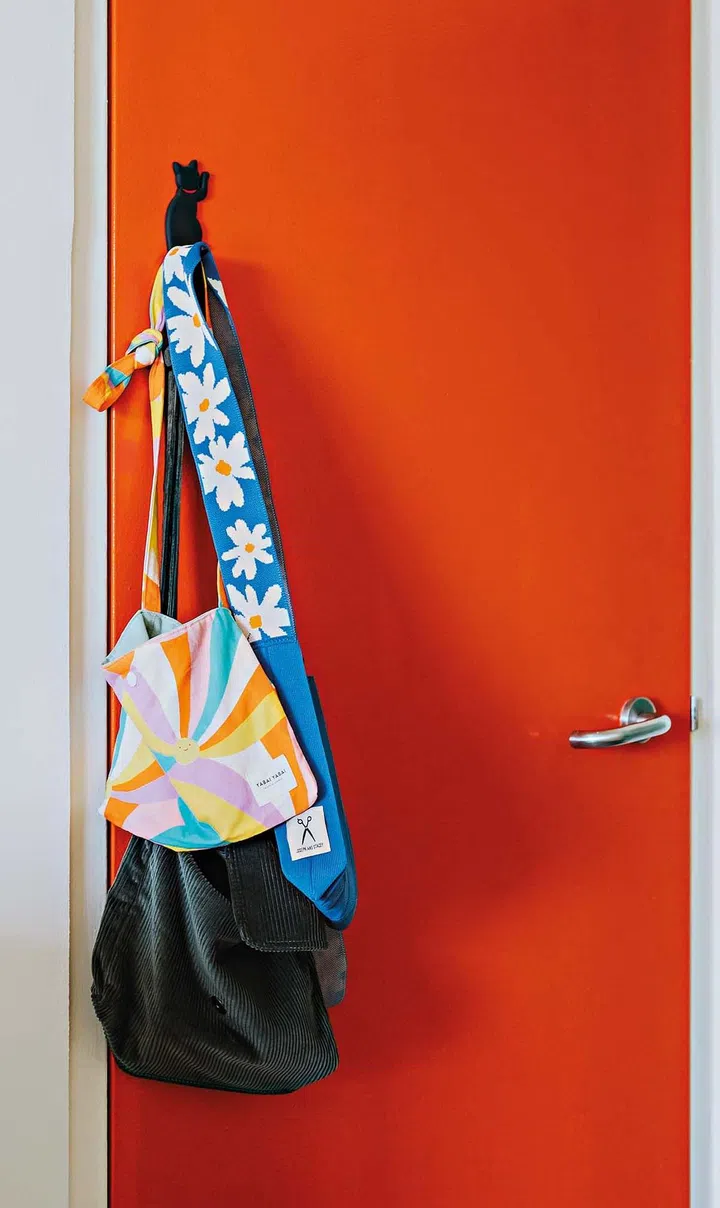 The couple used the door to the household shelter, near the main entrance, as a place to hang their often-used bags, making them a part of the decor.