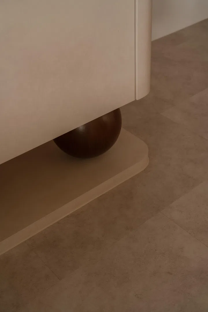 Seen up close, the timber sphere grounds the cabinetry while adding a tactile, sculptural detail to the otherwise restrained palette.