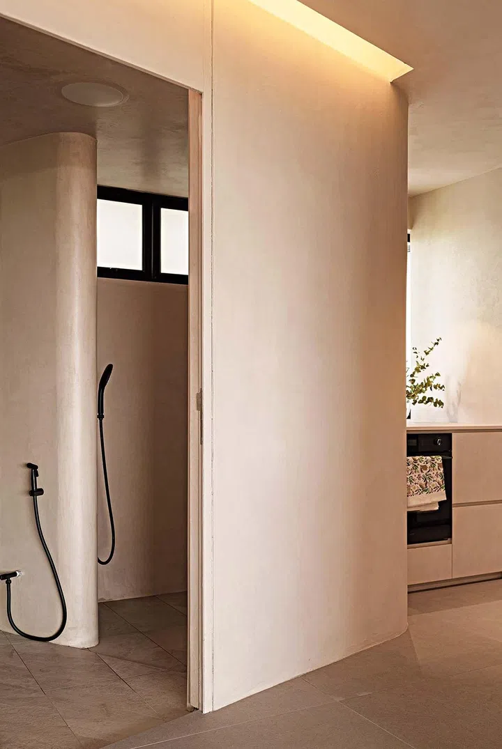 A curved shower
niche houses the
concealed piping
and separates
the WC from
the shower
compartment
in the common
bathroom.