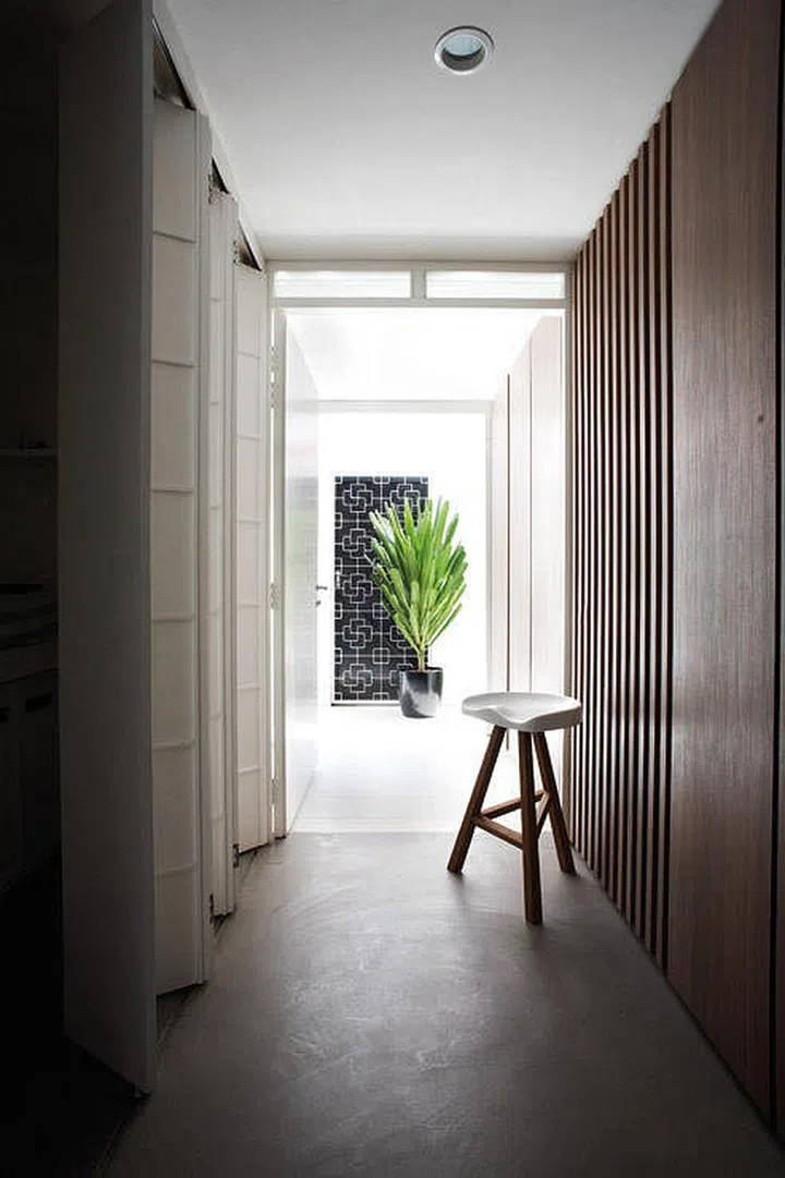 Rather than using the same materials for the surrounding walls of the corridor, this homeowner turned one wall into an accordion partition, and used wood on the other side.