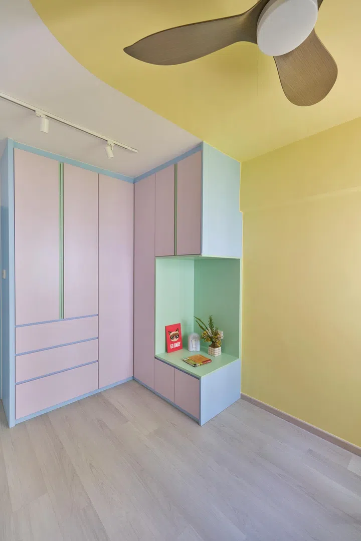 Qi Xuan introduced a butter yellow curve (Nippon Slight Embrace NP YO 1103P) in the ceiling, continuing down the wall. She paired this with Nippon Snow Flake 1164 to softly break the shape. Three colours were chosen for the custom-built cabinet in this Master Bedroom: Lamitak SCA5115D Ethan Blue, EDL ESG5710N Violet Clair and EDL ESG6300N Spring Green. 