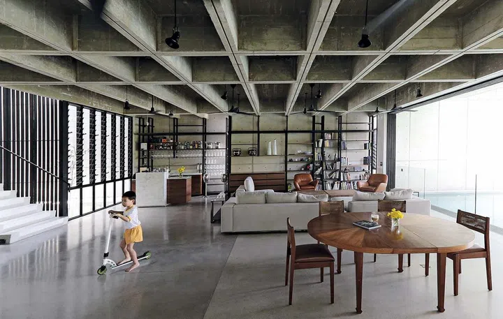 The living, dining and pool are positioned at the entry level and features concrete in various finishes in Chempenai House, Kuala Lumpur.