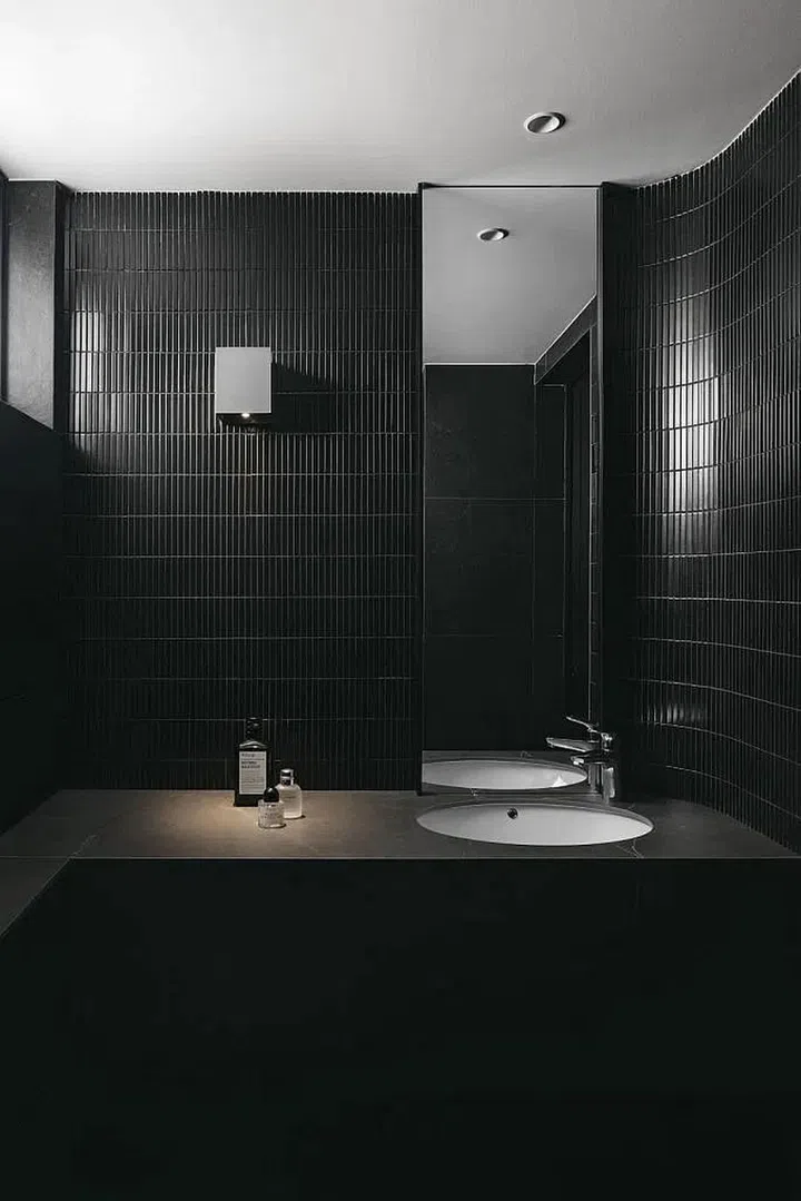 A design hack when using dark colour schemes: Layer the textures to maintain visual interest. In the master bathroom, gloss finish “kit kat” tiles offset the vanity counter.