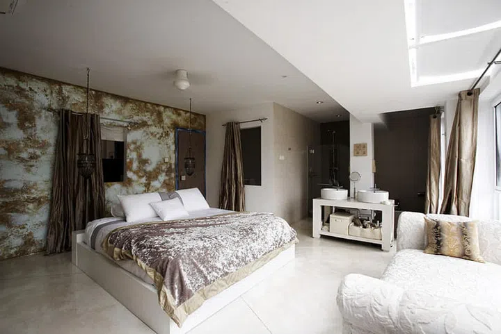 A palette of muted golds gives an understated, luxe look to the master bedroom and open bath. Velvets and silks are also used to "create a sensual and opulent space.