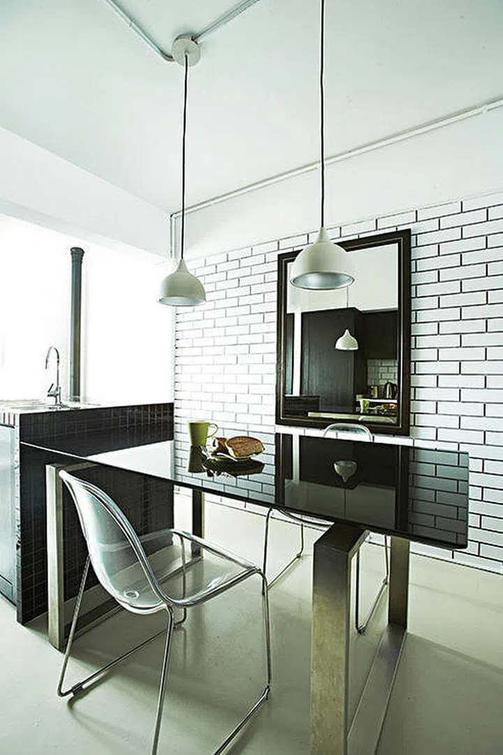 A simple dining area, put together with furniture from George’s previous home, is set up beside the customised kitchen island.