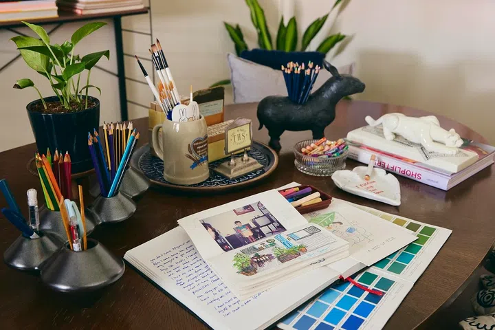 Sketchbooks, pencils and journals sit within reach, ready whenever inspiration strikes.
