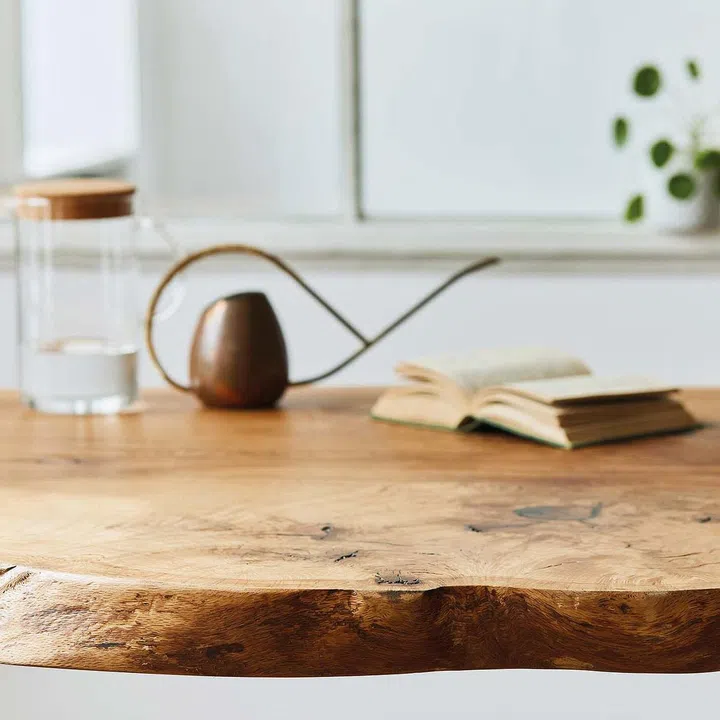 Stylish and cozy compositon of craft oak wooden table with chairs, watering can, glassy jug and modern floor in beautiful interior of design home. Template.