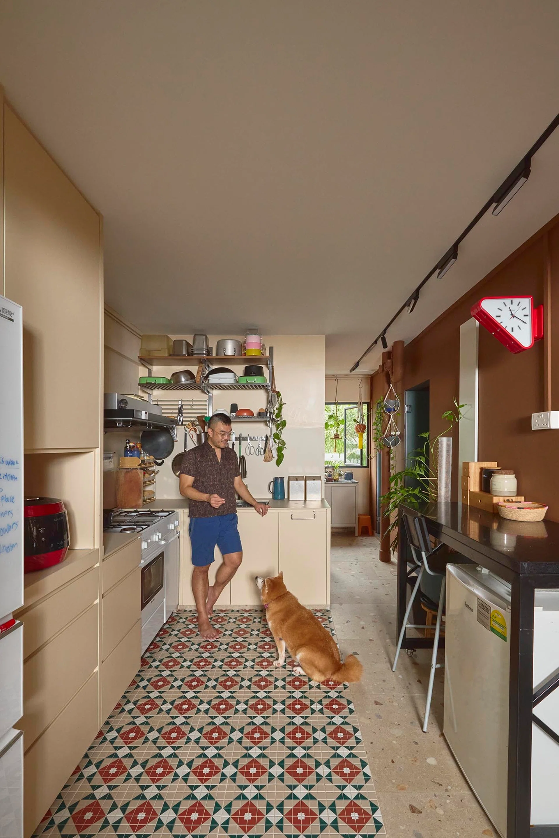 Spot the red triangle-shaped clock on the wall in his and his partner’s kitchen.