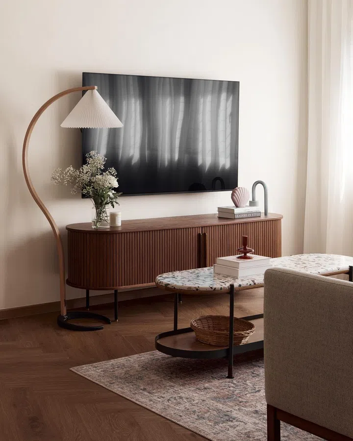Parquet floors, fluted wood TV console, terrazzo coffee tabletop, and a curved lamp pulls the Parisian-style interior design together in this Clydeswood Condominium apartment.