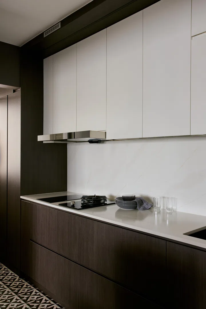 Deep browns contrast shades of white in the kitchen in a 5-room HDB BTO in Woodlands.