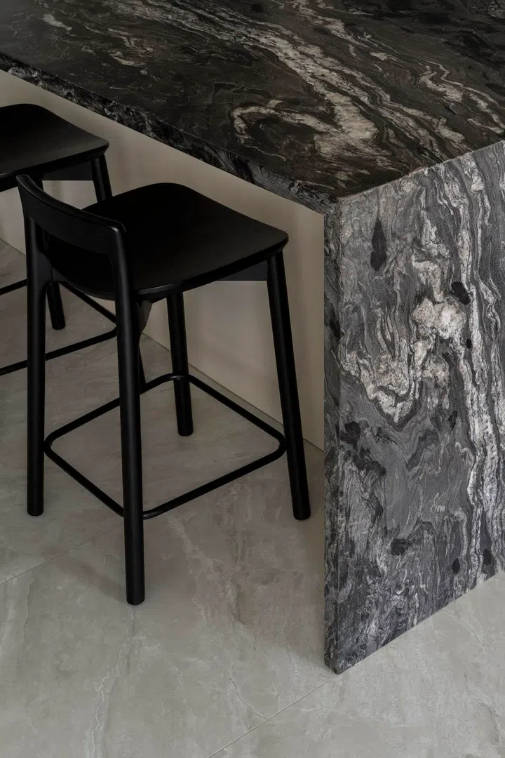 Details of the stone island showcase its textured grain, the visual anchor of the kitchen.