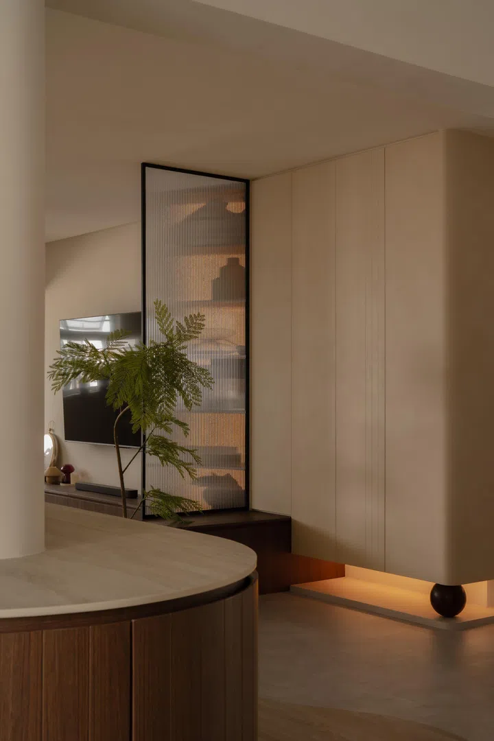 The same rounded motif reappears at the foyer shoe cabinet, creating a subtle design thread between arrival and living spaces.